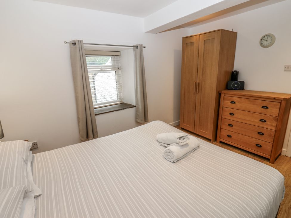 A bedroom with a bed and furniture at Mill Race House in Alston