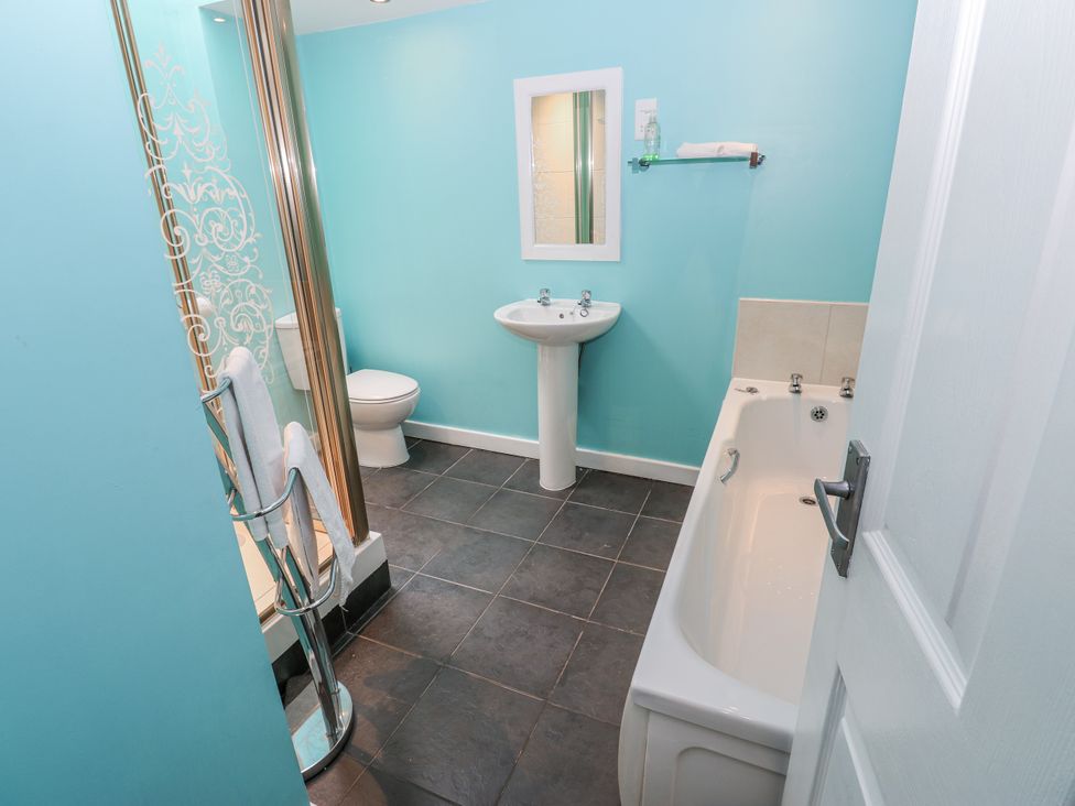 A bathroom with a shower, sink, toilet, and bathtub at Mill Race House Alston