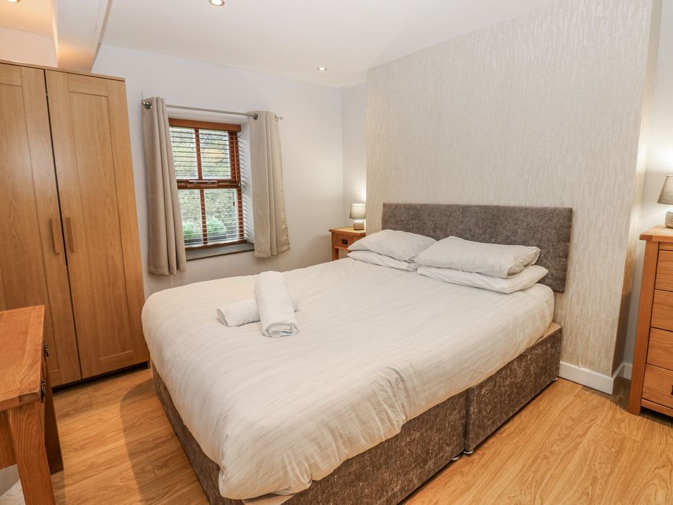 A bedroom with a bed and wooden furniture at Mill Race House in Alston