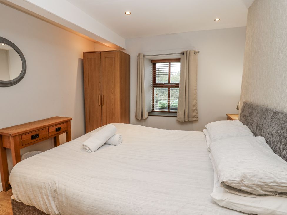 A bedroom with a bed and wardrobe at Mill Race House in Alston