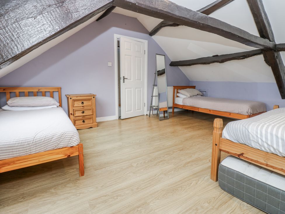 A bedroom with three beds and a nightstand at Mill Race House in Alston