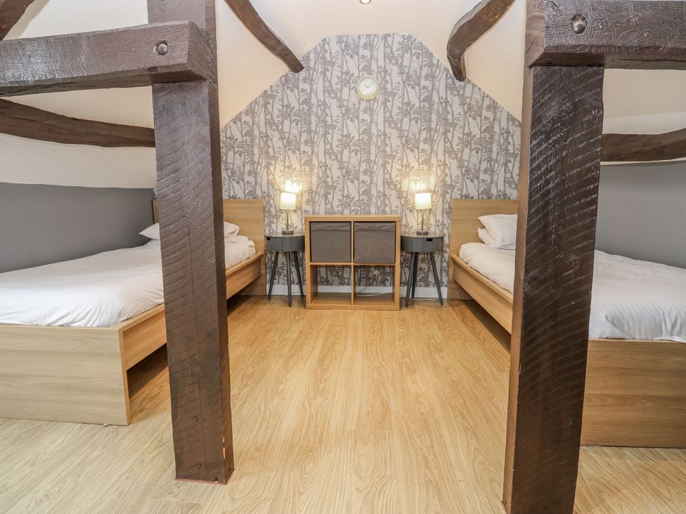 A bedroom with two beds and a table at Mill Race House in Alston