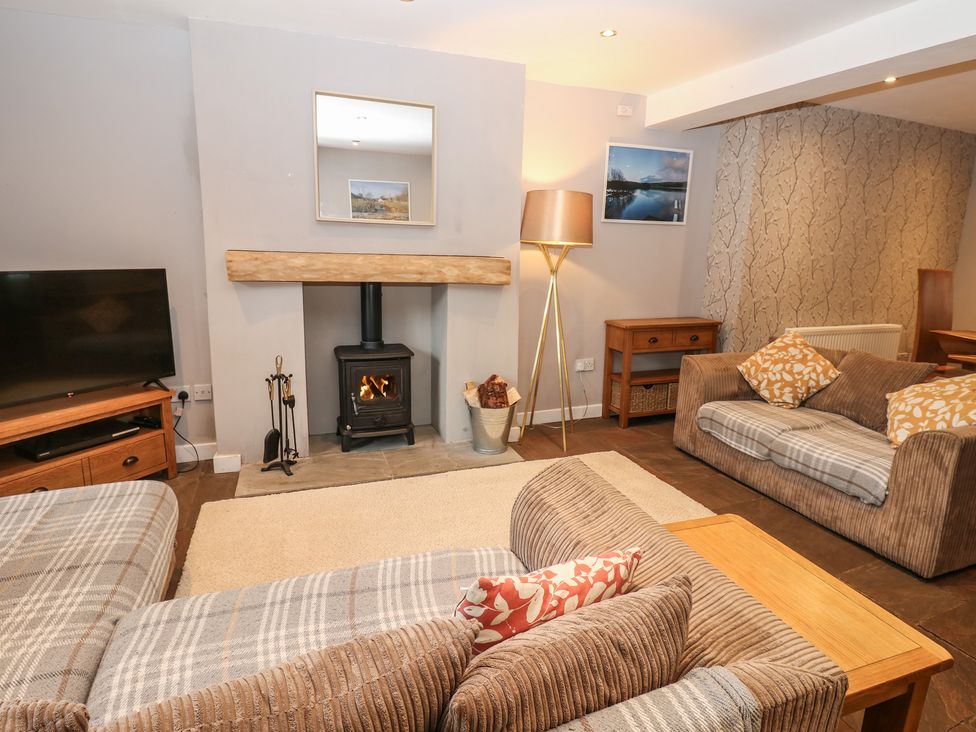 A living room with a television and sofa at Mill Race House in Alston