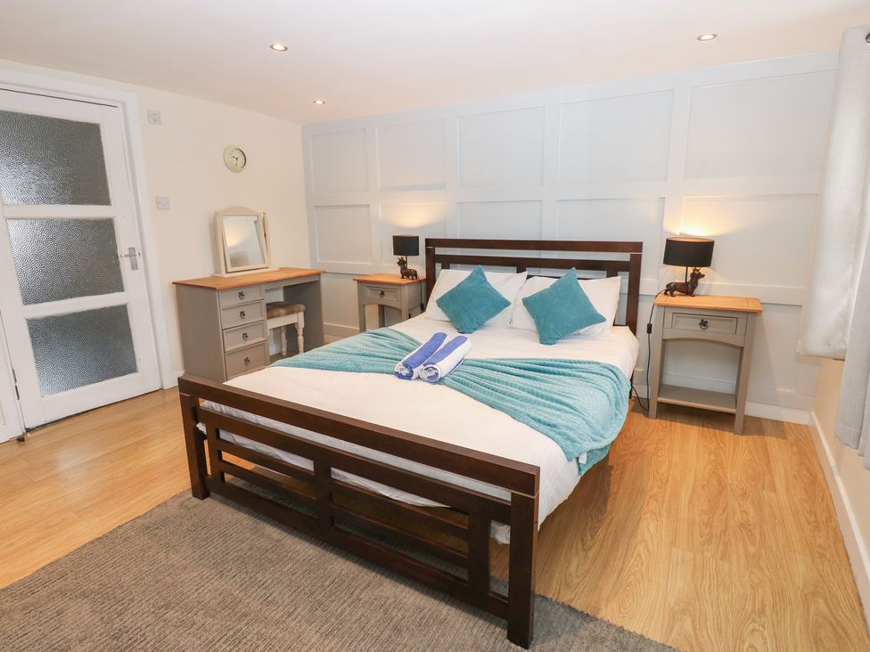 A bedroom with a bed and bedside tables at Mill Race House Alston