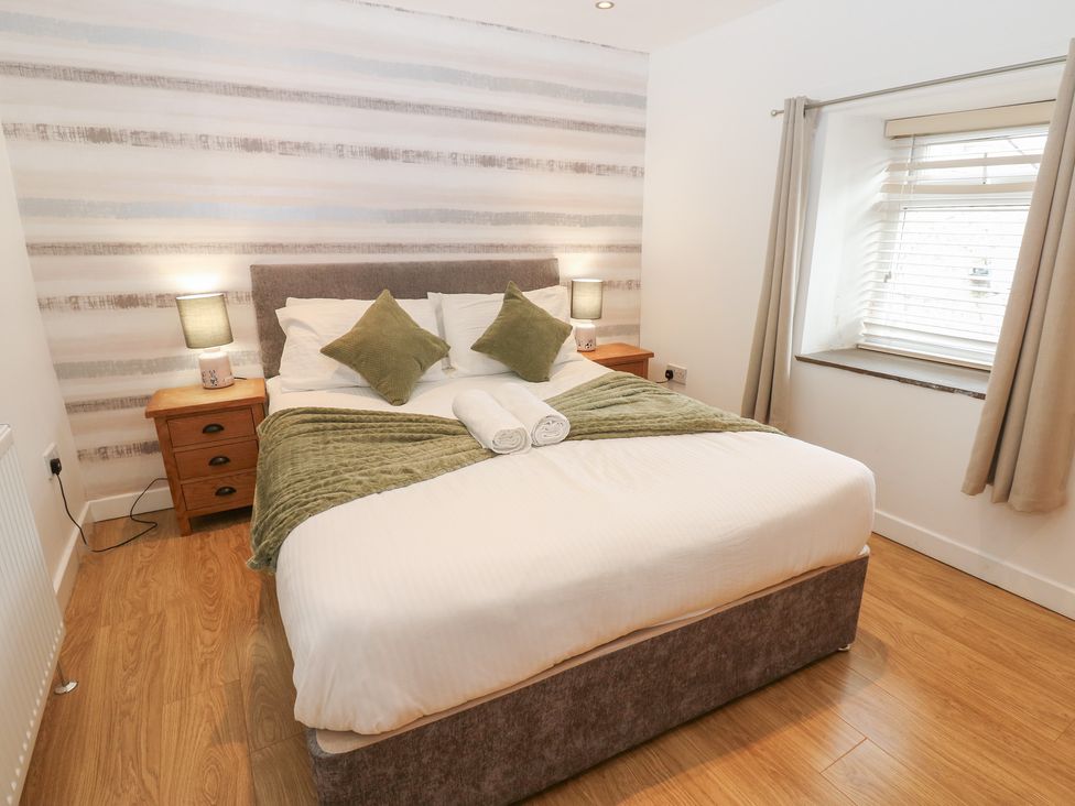 A bedroom with a bed and bedside table at Mill Race House Alston