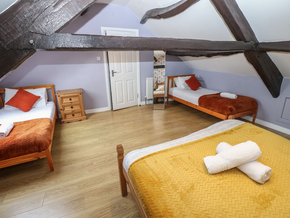 A bedroom with three beds and a dresser at Mill Race House in Alston
