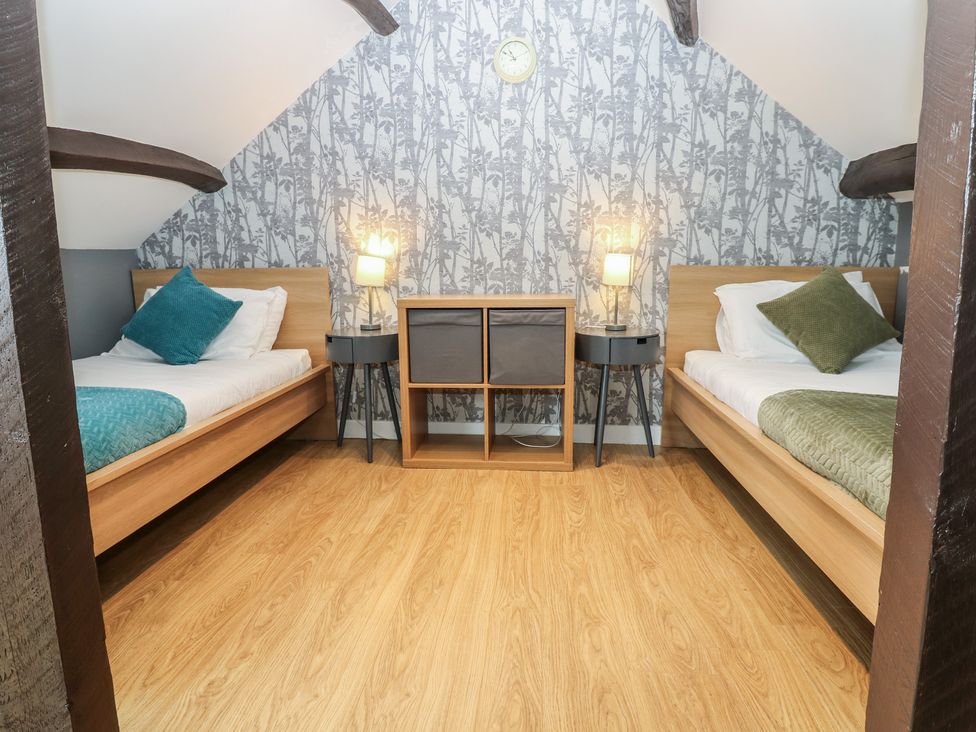 A bedroom with two beds and a storage unit at Mill Race House Alston