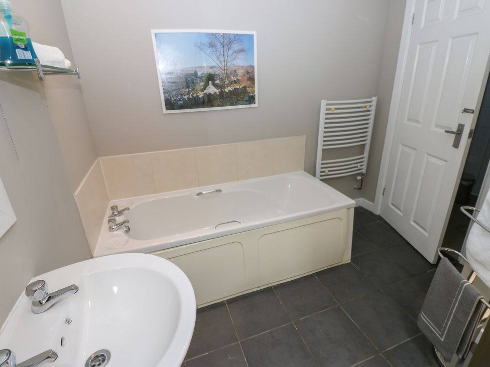 A bathroom with a bathtub and sink at Mill Race House Alston