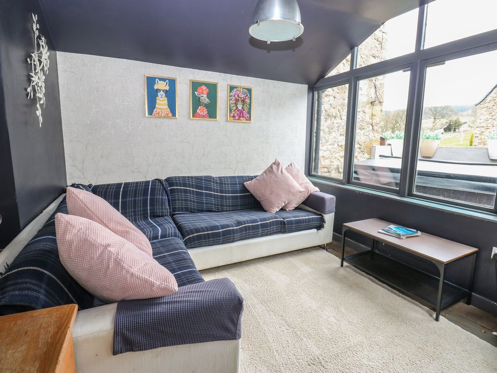 A snug with a sofa and coffee table at Mill Race House in Alston