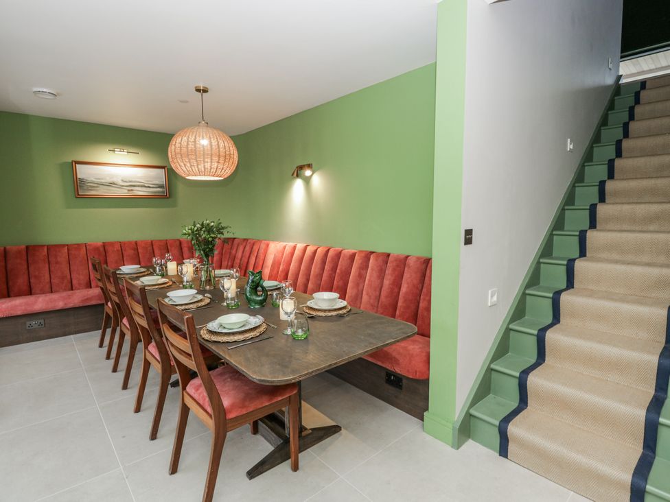 A dining room with a table and chairs at Twyn Isaf in Borth