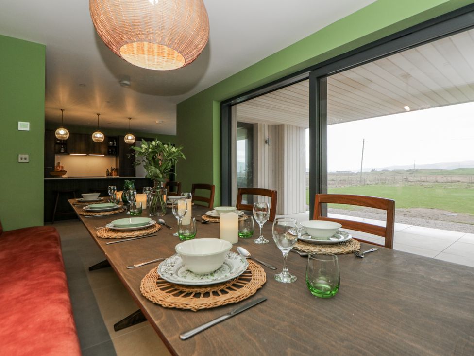 A dining room with a table set for a meal at Twyn Isaf in Borth