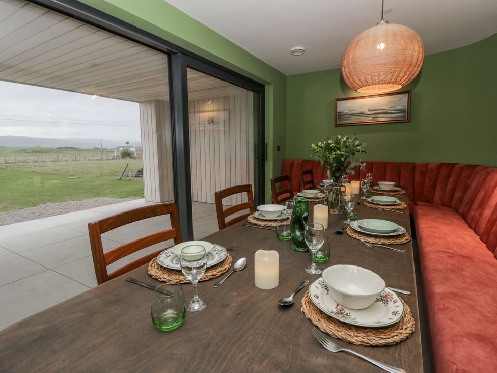 A dining room with a table set for a meal at Twyn Isaf in Borth