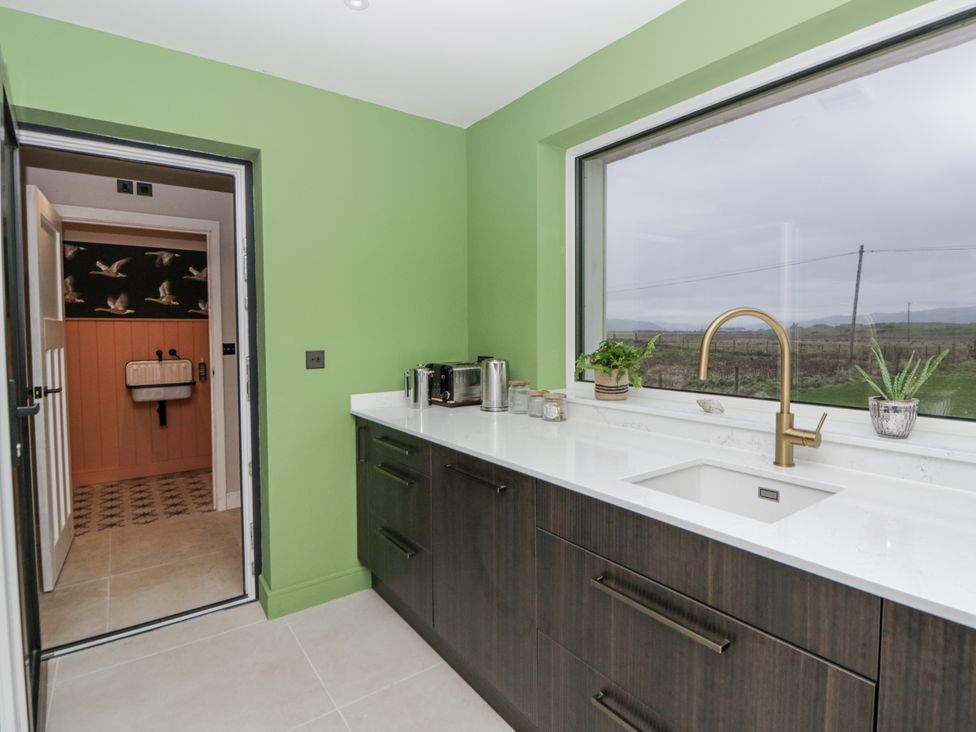 A kitchen with a sink and cabinetry at Twyn Isaf in Borth