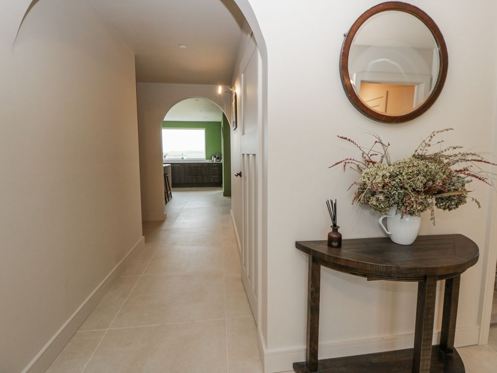 A hallway with a table and mirror at Twyn Isaf Borth