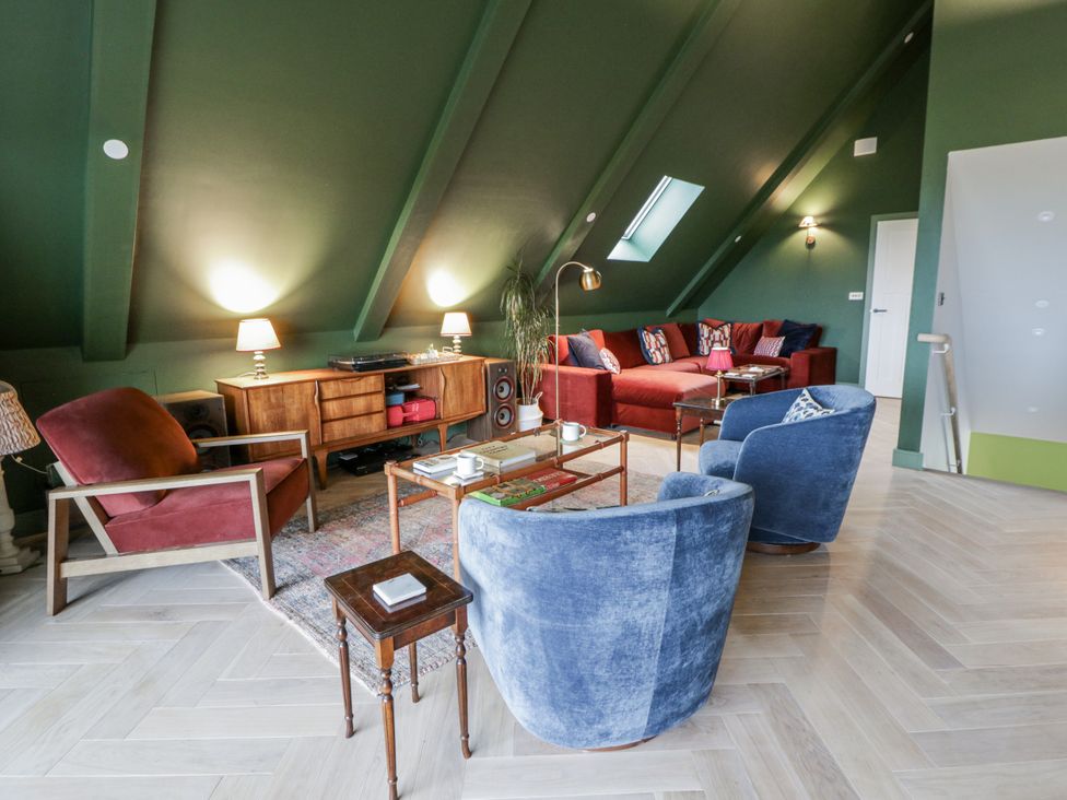 A living room with seating and a media unit at Twyn Isaf Borth