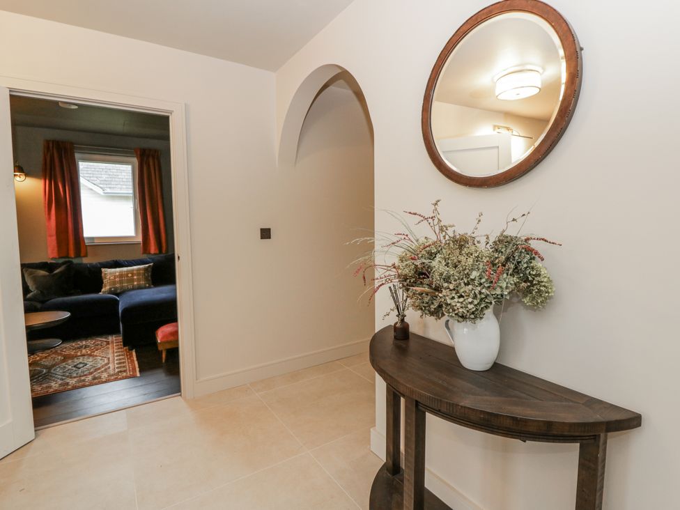 A hallway with a mirror and console table at Twyn Isaf, Borth