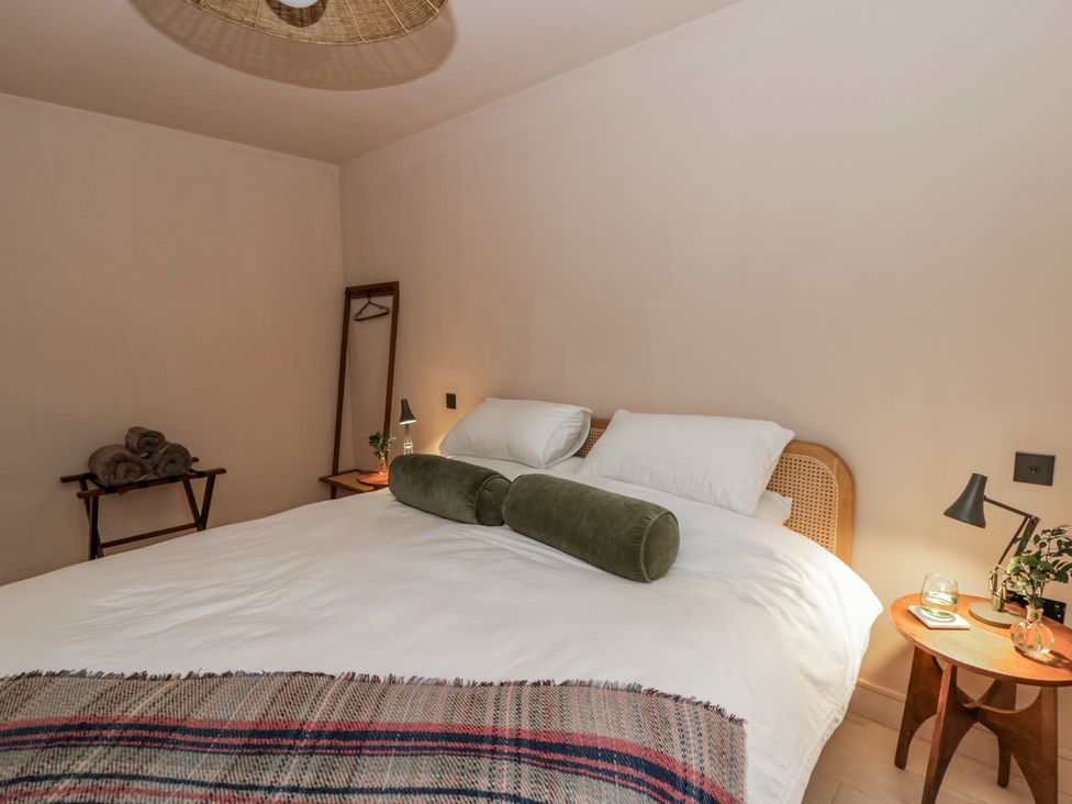 A bedroom with a bed and side table at Twyn Isaf in Borth