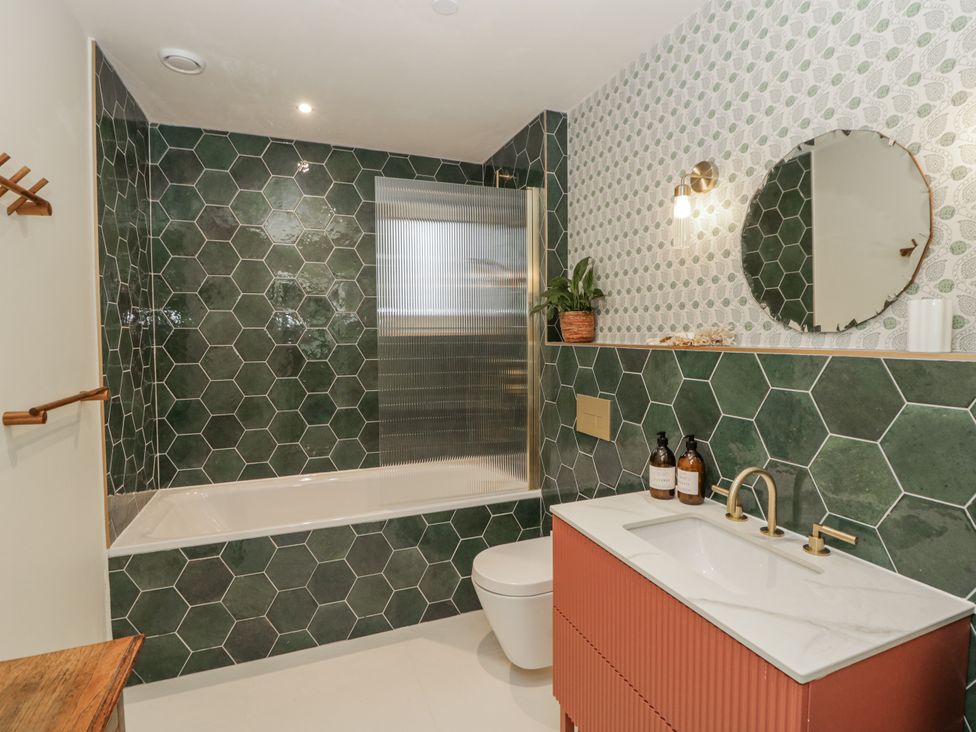 A bathroom with a bathtub and sink at Twyn Isaf in Borth