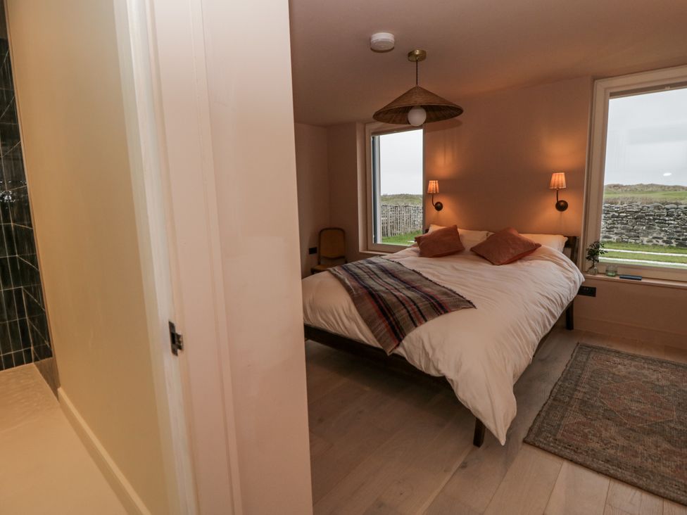 A bedroom featuring a bed with pillows at Twyn Isaf in Borth