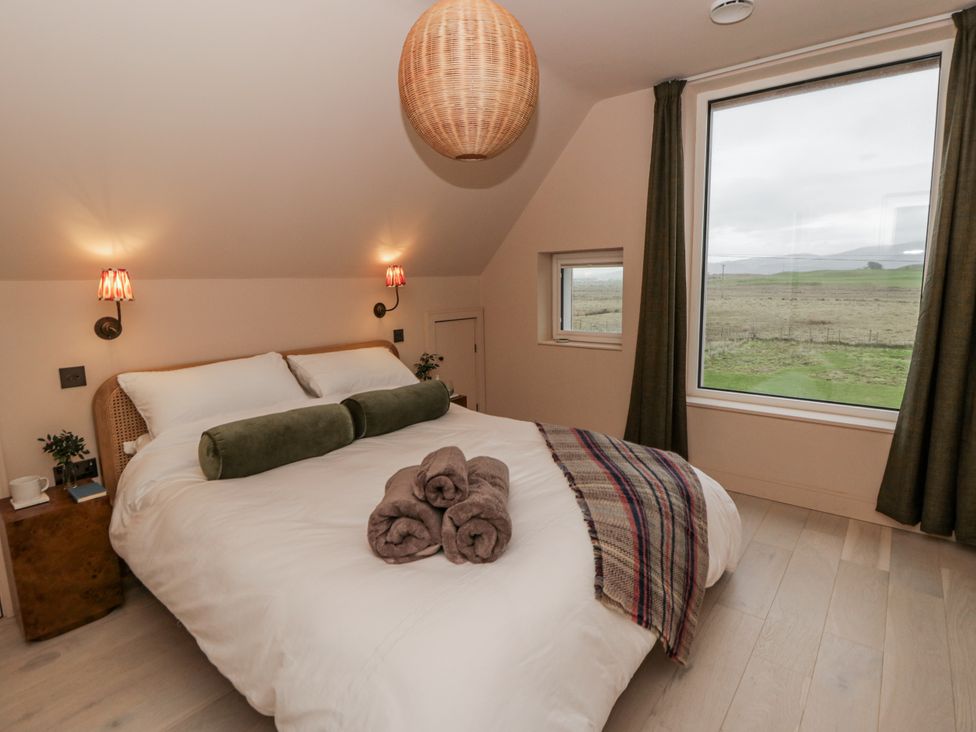 A bedroom with a bed and window view at Twyn Isaf in Borth