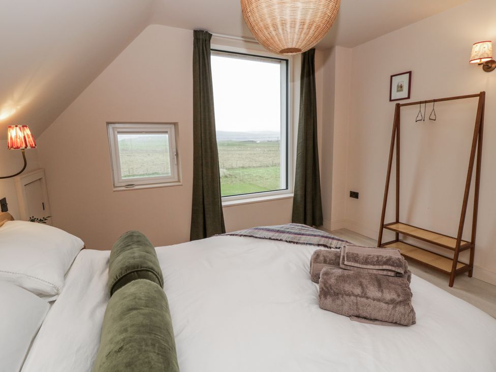 A bedroom with a bed and lamp at Twyn Isaf, Borth