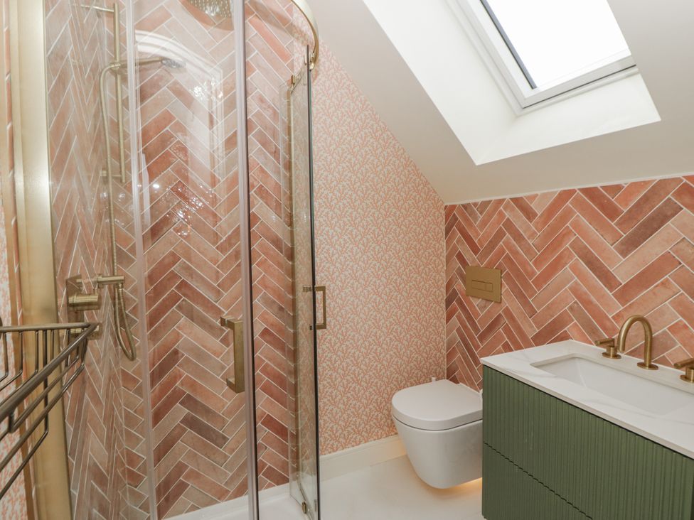 A bathroom with a shower, sink, and toilet at Twyn Isaf in Borth