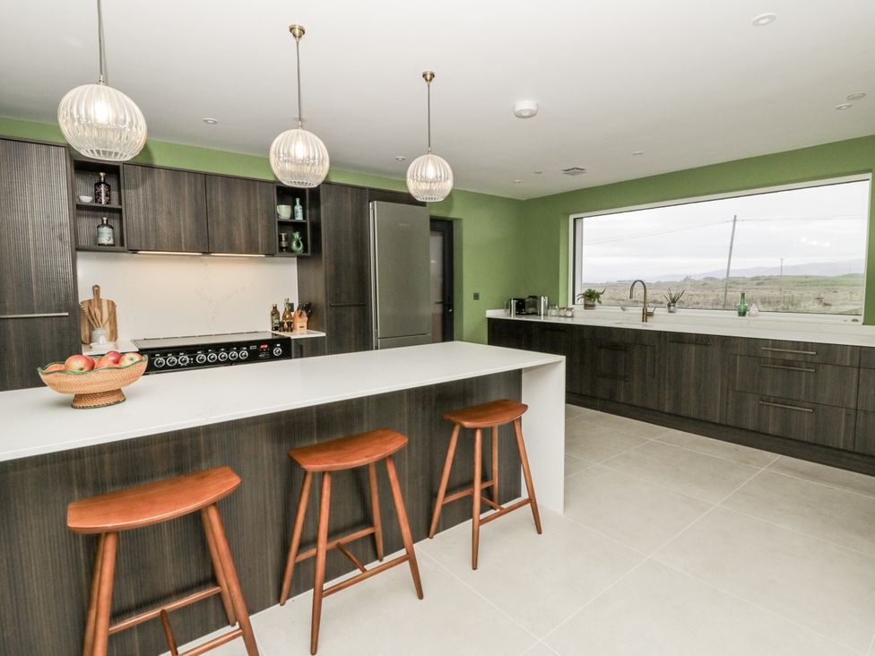 A kitchen with modern fixtures and a large window at Twyn Isaf in Borth