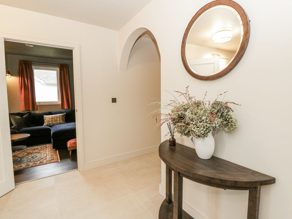 A hallway with a console table and flowers at Twyn Isaf in Borth