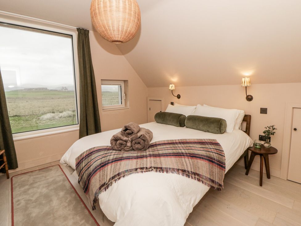 A bedroom with a bed and large window at Twyn Isaf in Borth