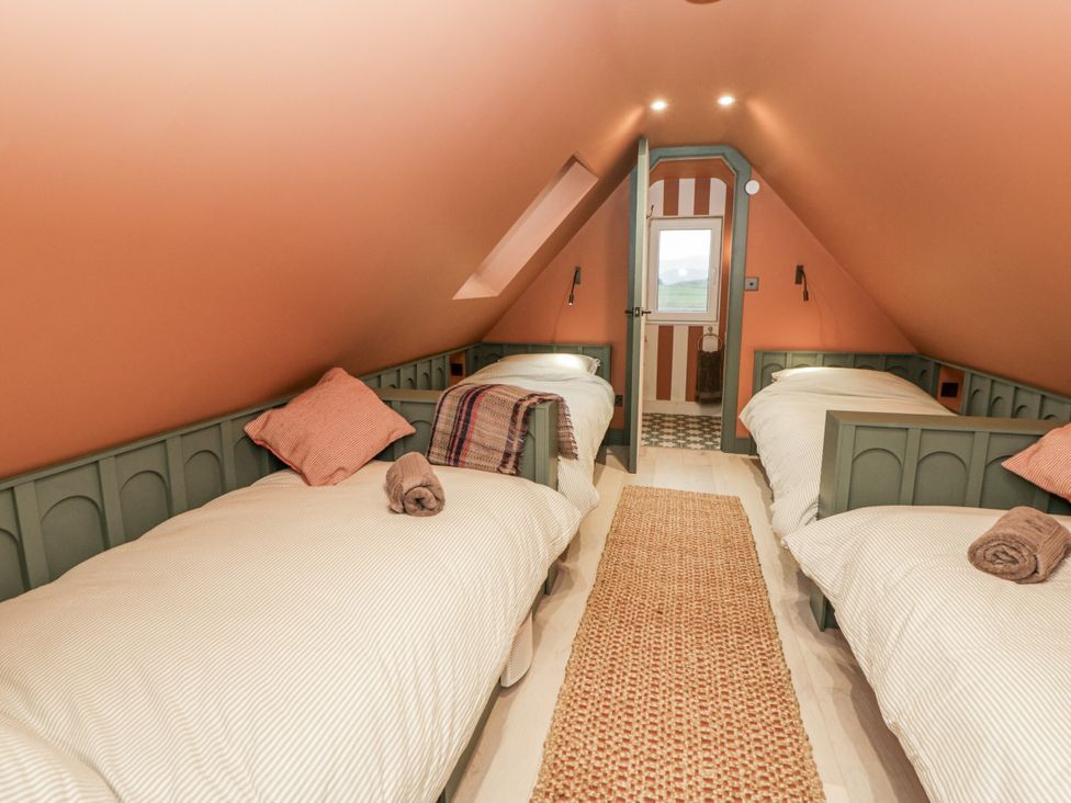 A bedroom with twin beds and a window at Twyn Isaf in Borth