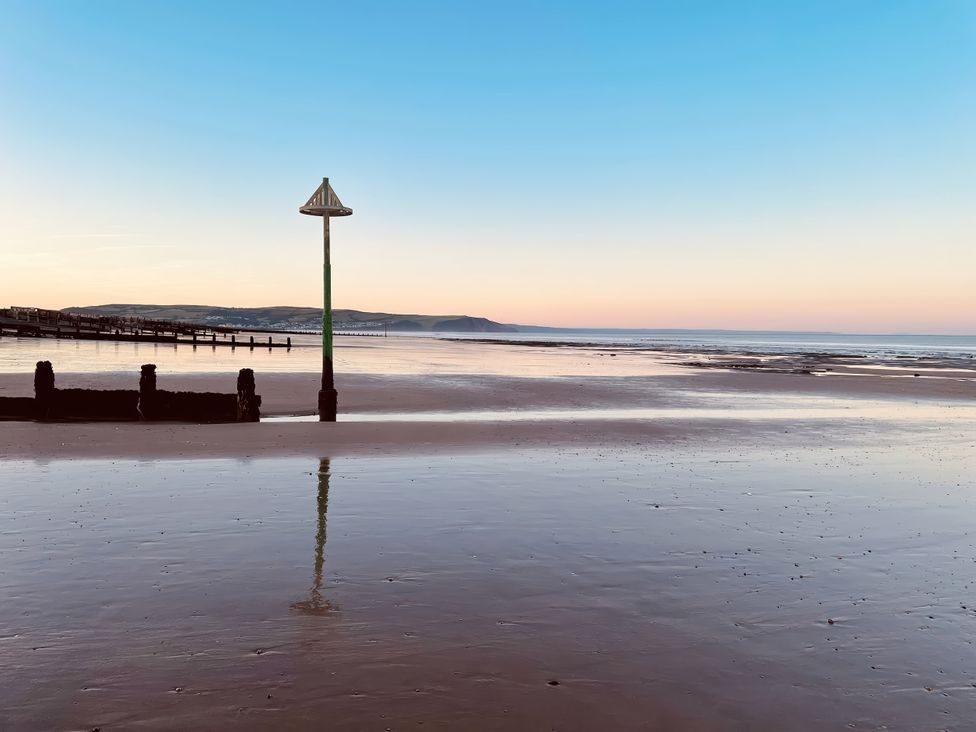A beach with a fishing pier and lamp post at Twyn Isaf Borth