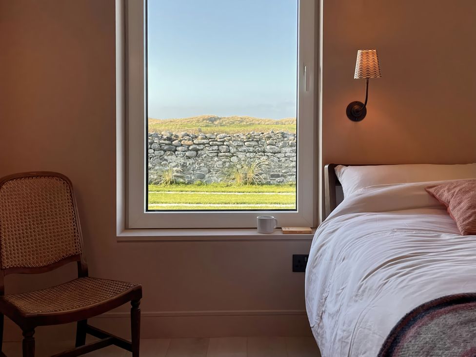 A bedroom with a window and a chair at Twyn Isaf in Borth