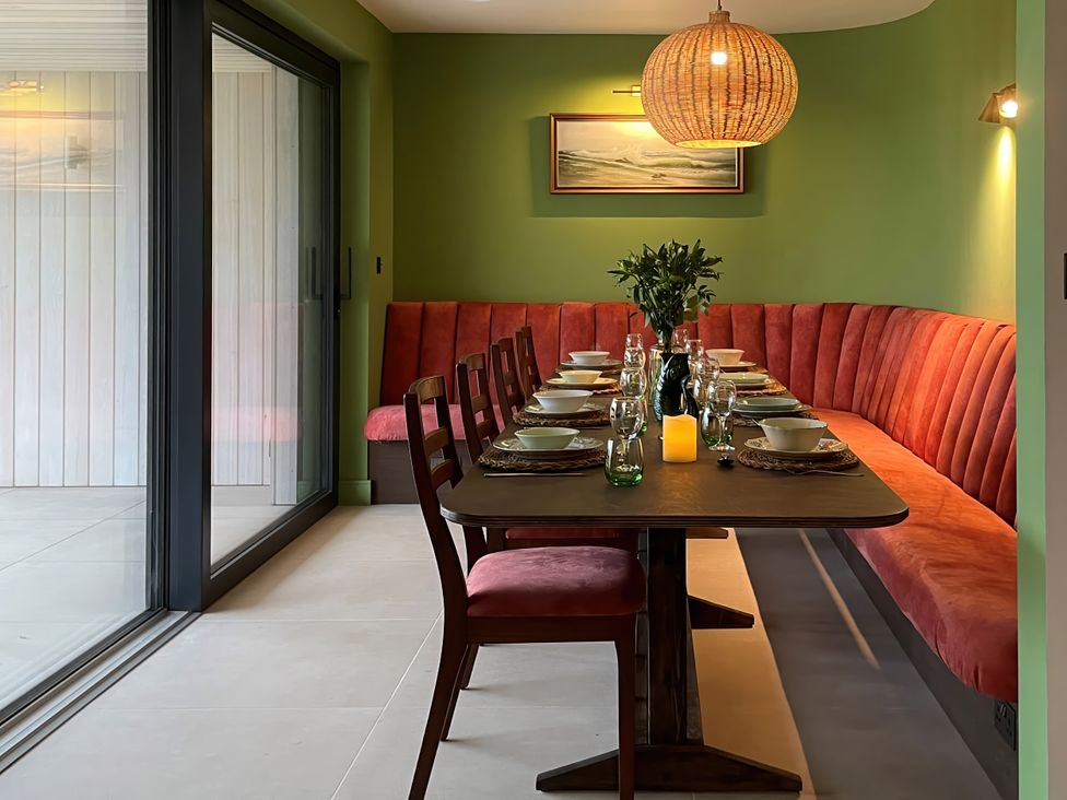A dining room with a table and chairs at Twyn Isaf in Borth