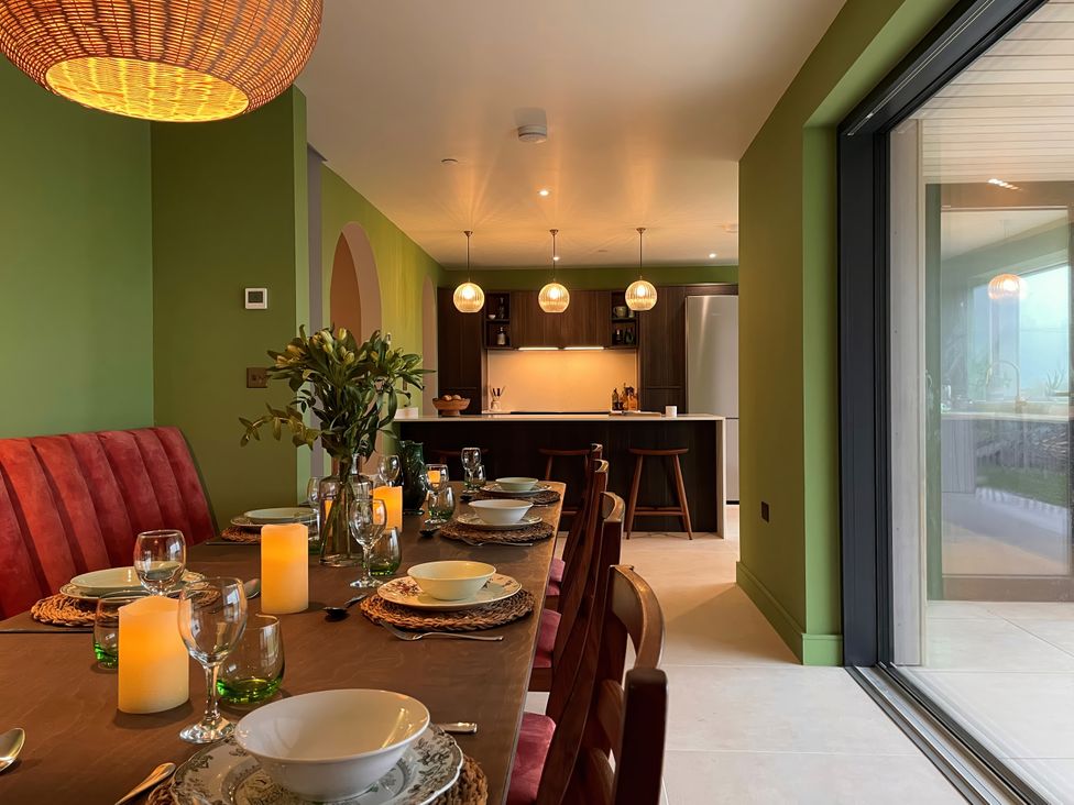 A dining room with a table set for a meal at Twyn Isaf in Borth