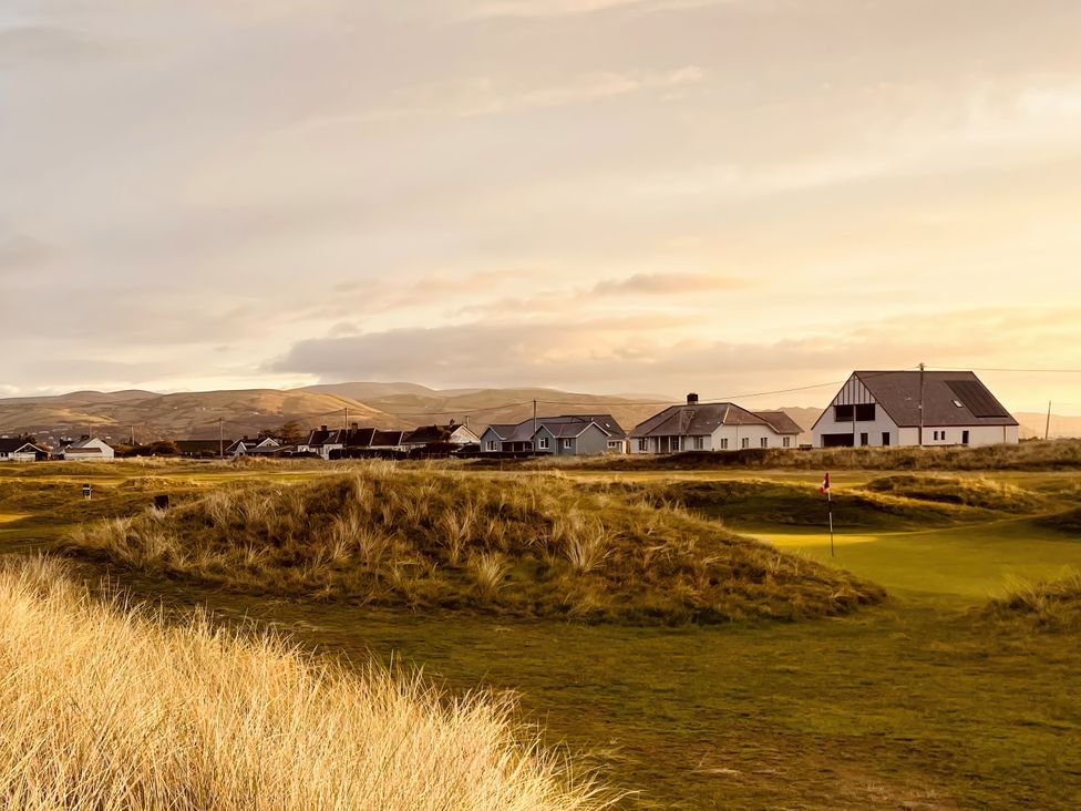 A golf course with houses and hills at Twyn Isaf Borth