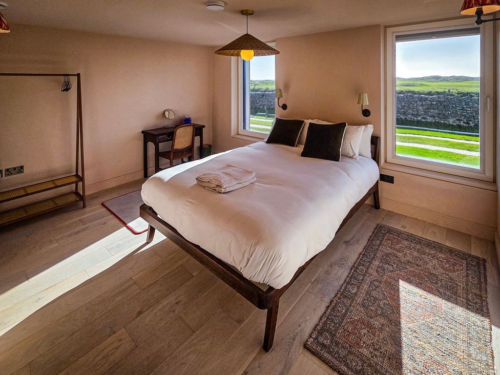 A bedroom with a bed and desk at Twyn Isaf in Borth