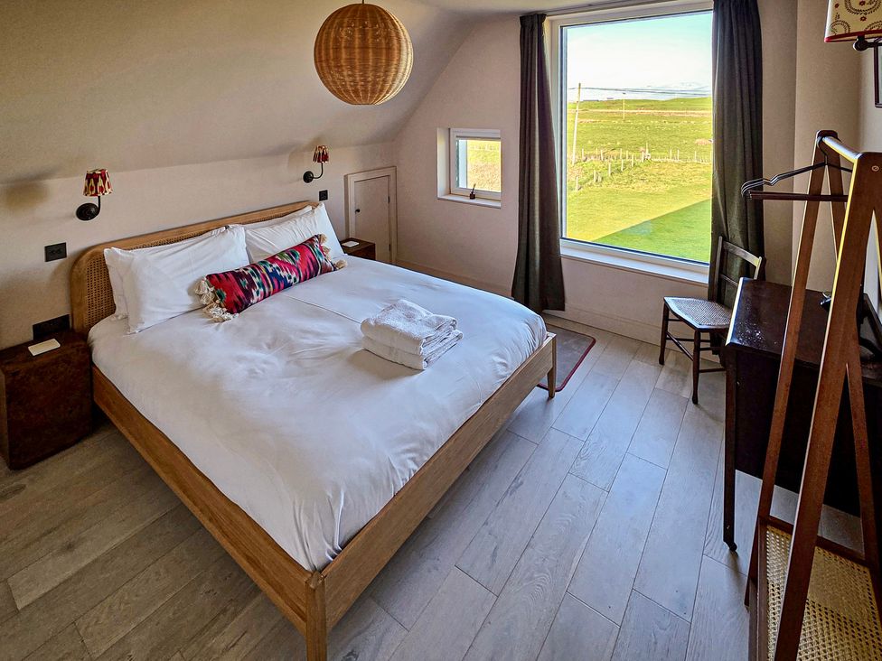 A bedroom with a bed and window view at Twyn Isaf Borth