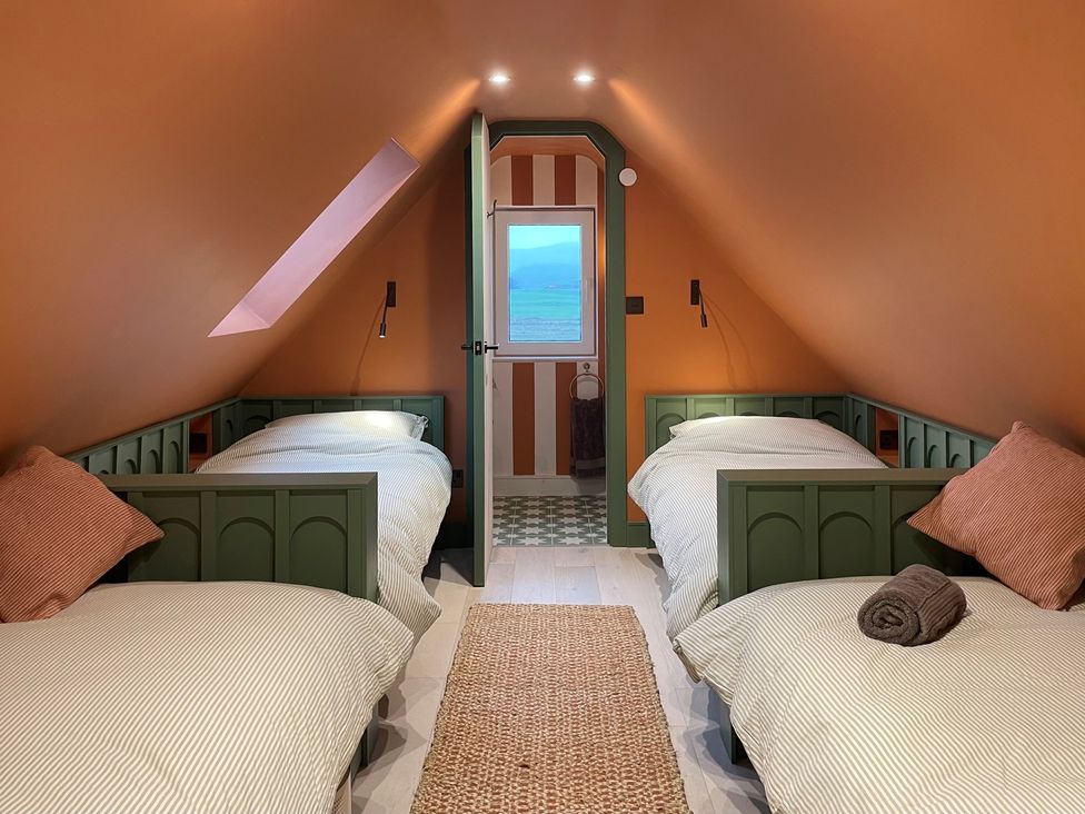 A bedroom with two beds and a window at Twyn Isaf in Borth