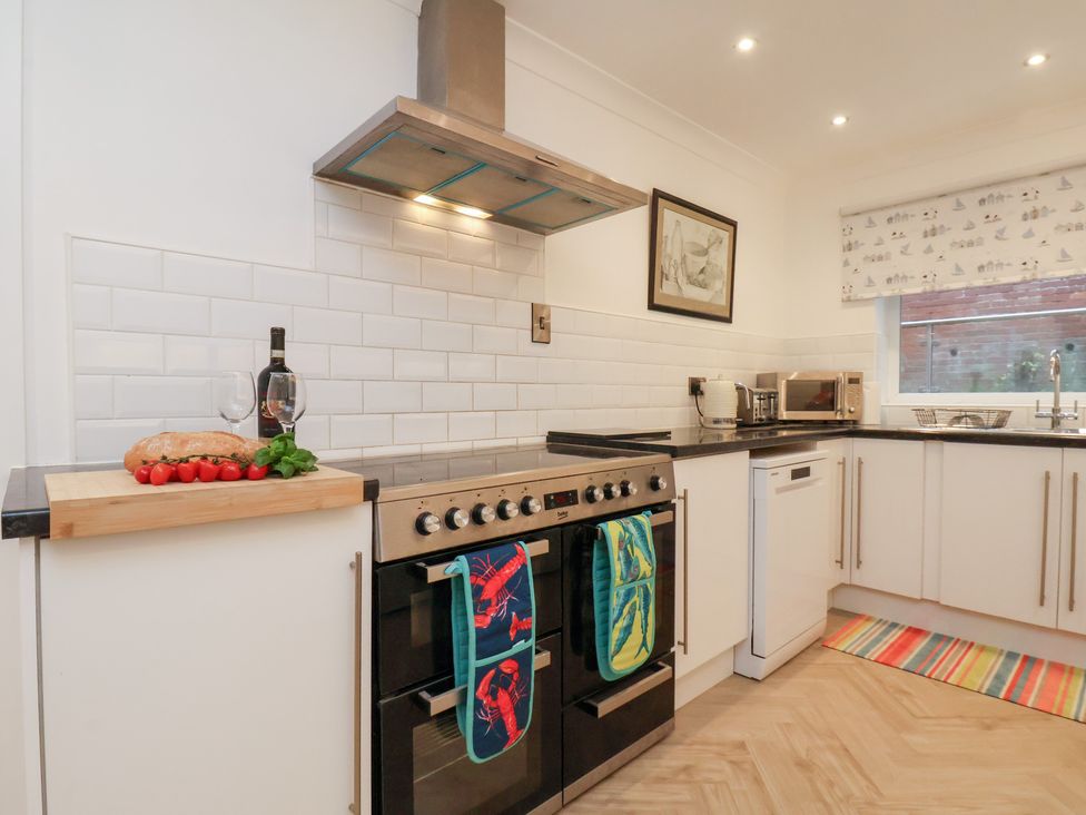 A kitchen with an oven and wine on the counter at 32 Quay Street Scarborough
