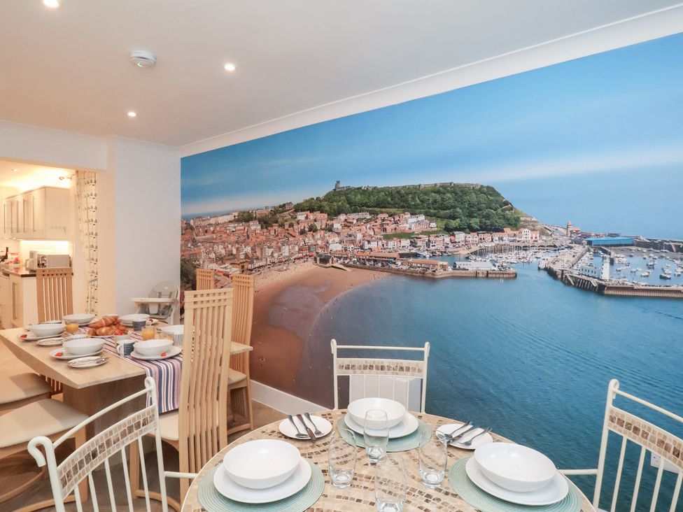 A dining room with a wall mural and a table set at 32 Quay Street in Scarborough
