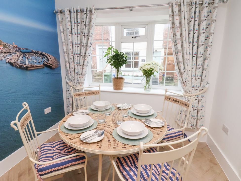 A dining room with a table set for meals at 32 Quay Street Scarborough