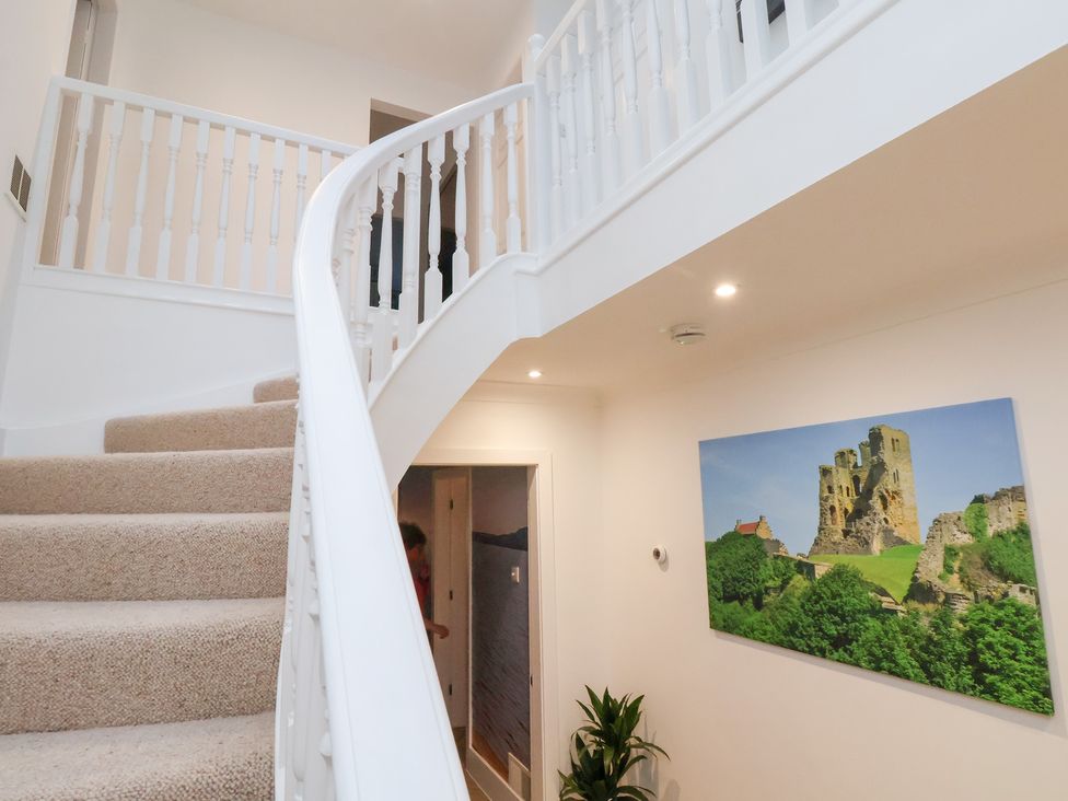 A staircase with a railing and a picture of a castle in 32 Quay Street Scarborough