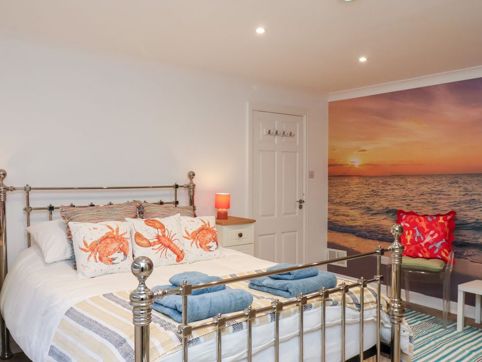 A bedroom with a metal bed and wall art at 32 Quay Street in Scarborough