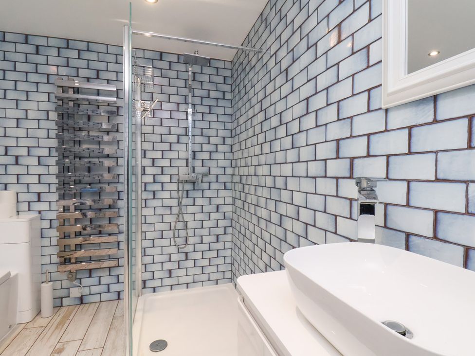 A bathroom featuring a shower, toilet, and sink at 32 Quay Street in Scarborough