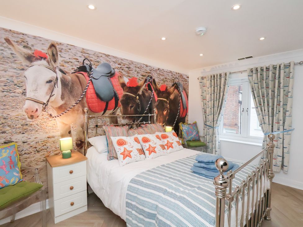 A bedroom with a bed and wall mural at 32 Quay Street in Scarborough