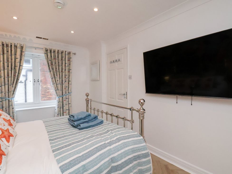 A bedroom with a bed and television at 32 Quay Street Scarborough