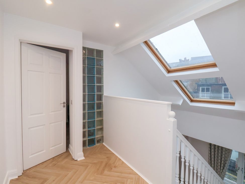 A hallway with a door, glass blocks, skylight, and staircase at 32 Quay Street Scarborough