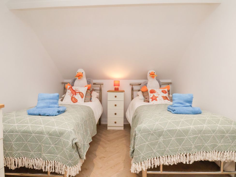 A bedroom with two beds and a bedside lamp at 32 Quay Street in Scarborough