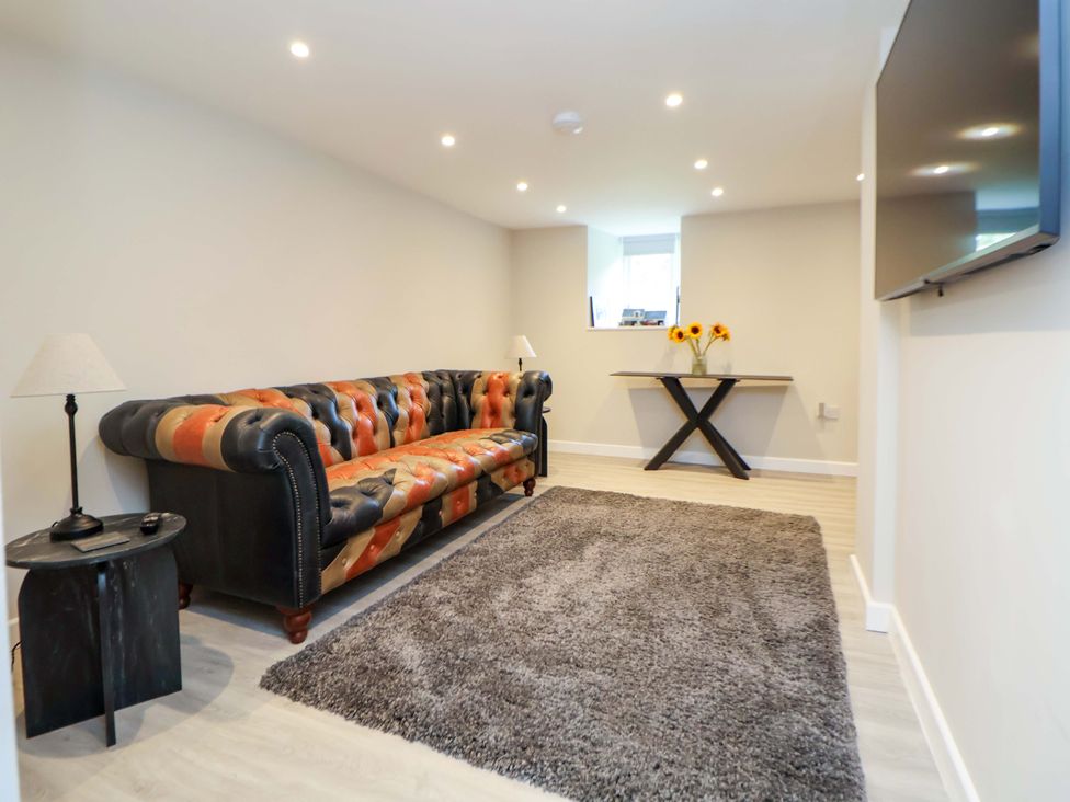 A living room with a sofa, table and television at Cartref, Pen Y Ball near Holywell