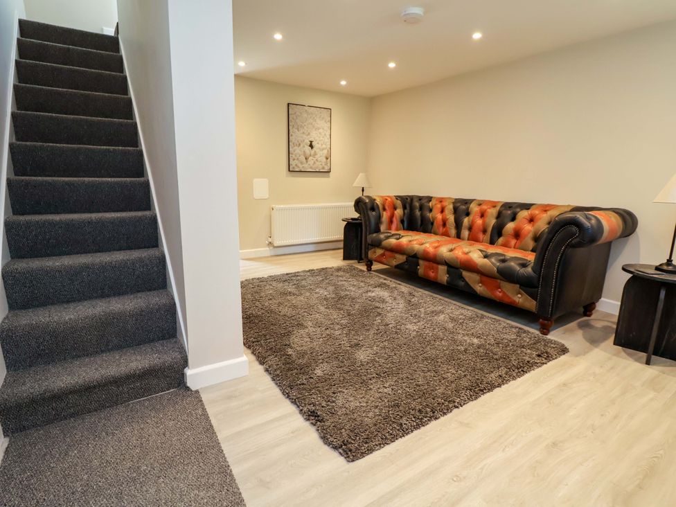A living room with a sofa and rug at Cartref Pen Y Ball near Holywell